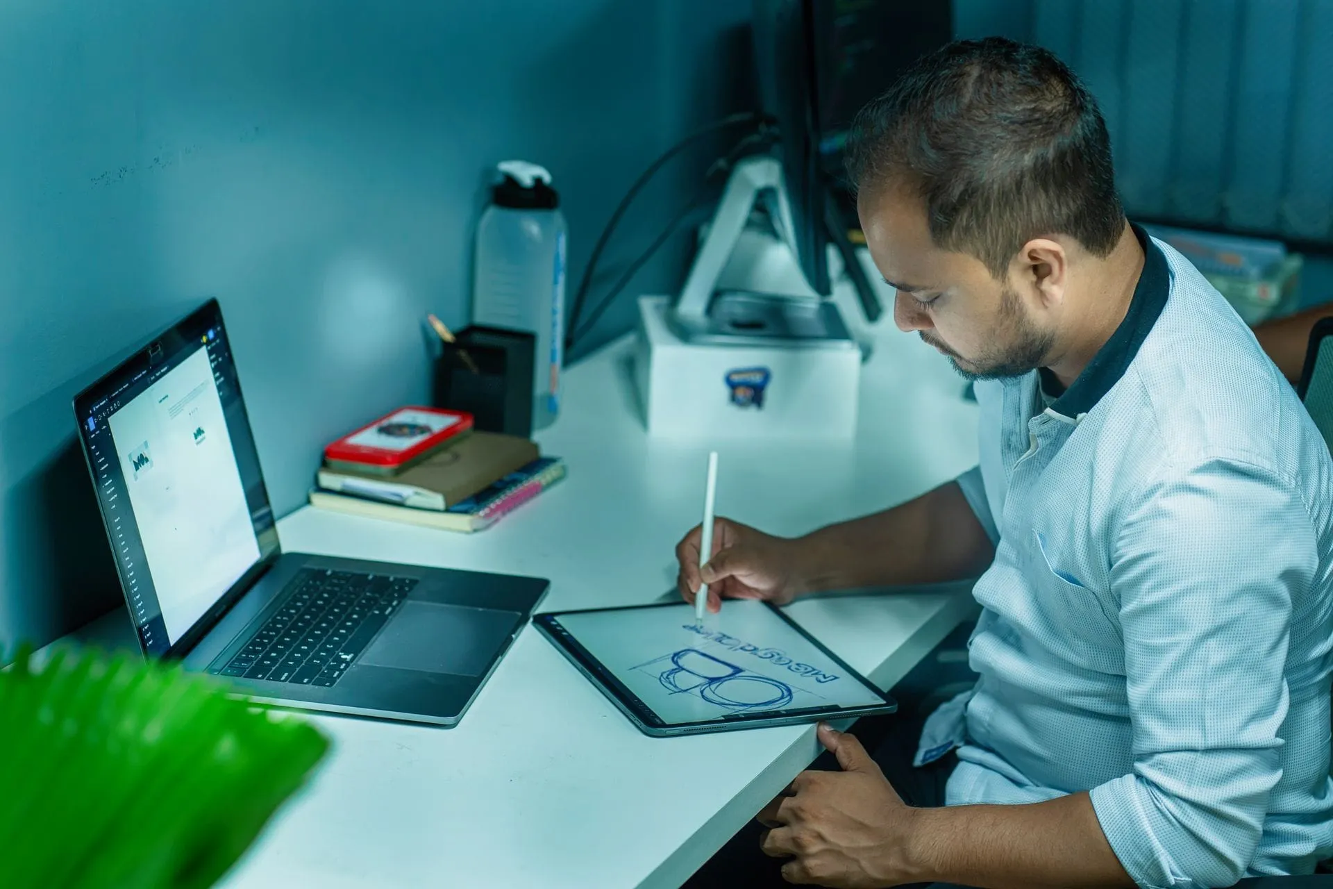 Indian designer sketching a design on a tablet at his desk